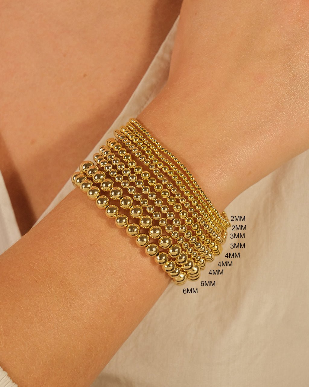 Gold three-piece beaded stretch bracelet set styled on the wrist